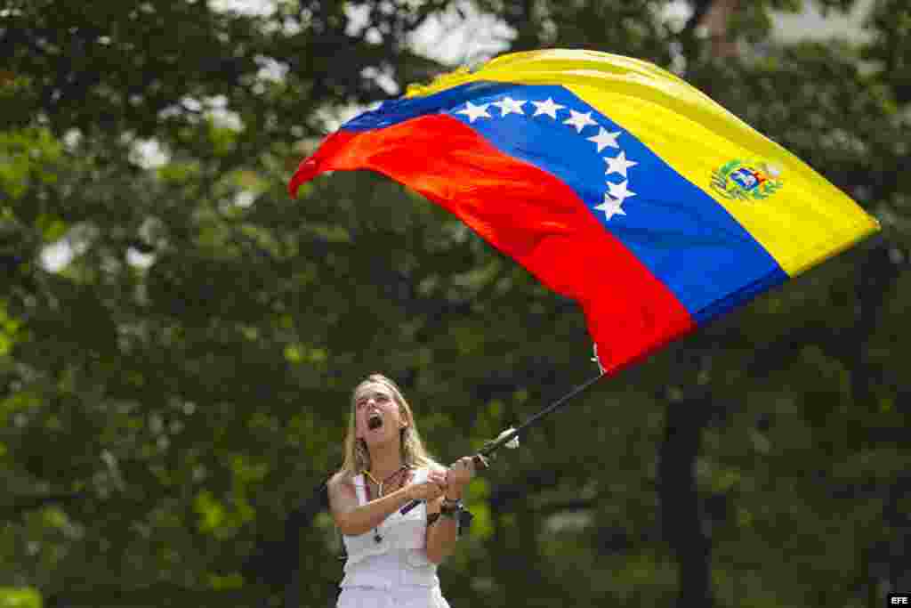 La esposa del dirigente opositor detenido por las autoridades venezolanas Leopoldo López, Lilian Tintori, ondea una bandera de Venezuela.